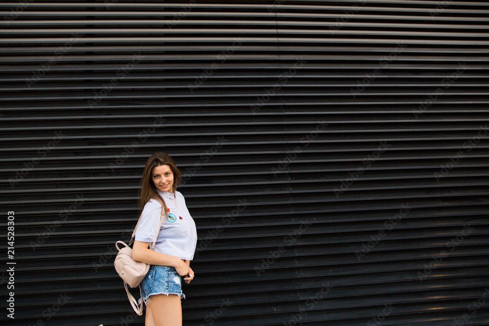 Obraz premium Young happy woman jump near city building wall