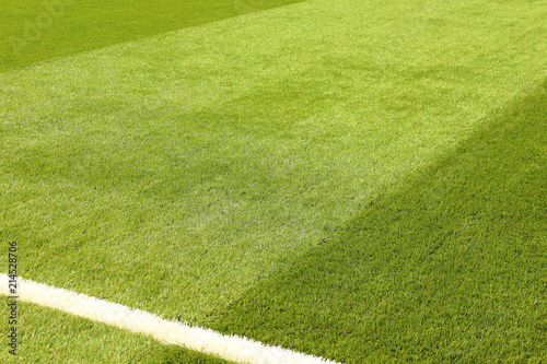 Artificial synthetic lawn on a football field. Close-up. Background. Texture.