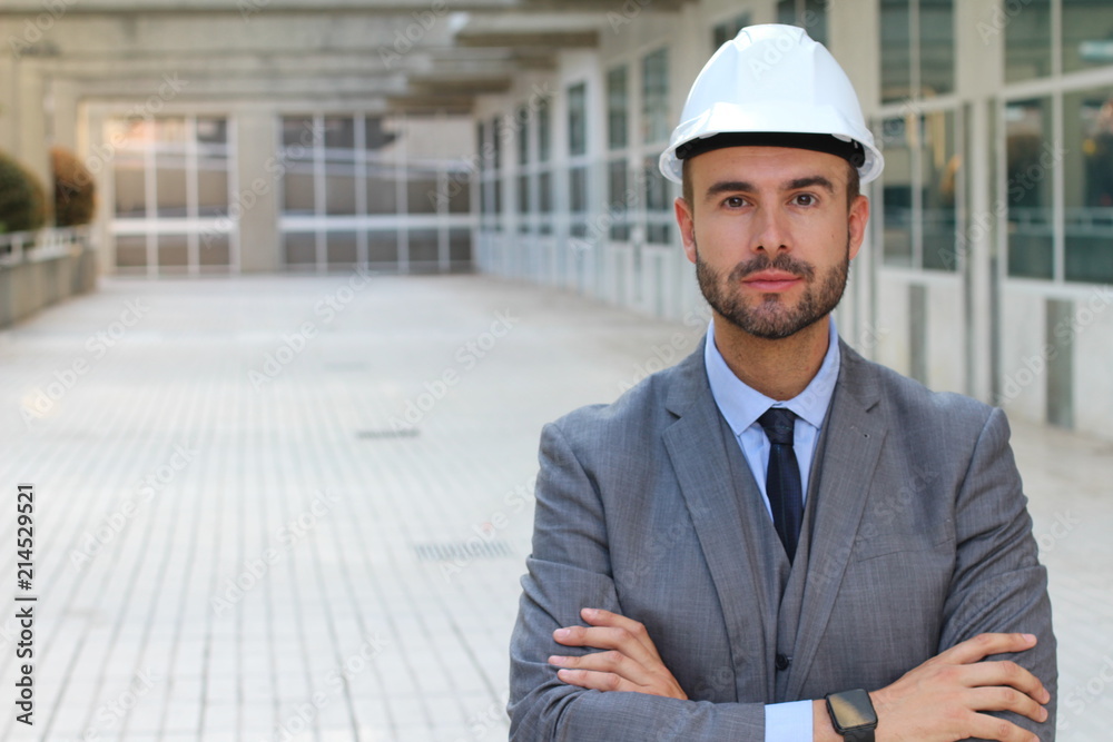Engineer with white helmet smiling in office space Engineer with white helmet smiling in office space