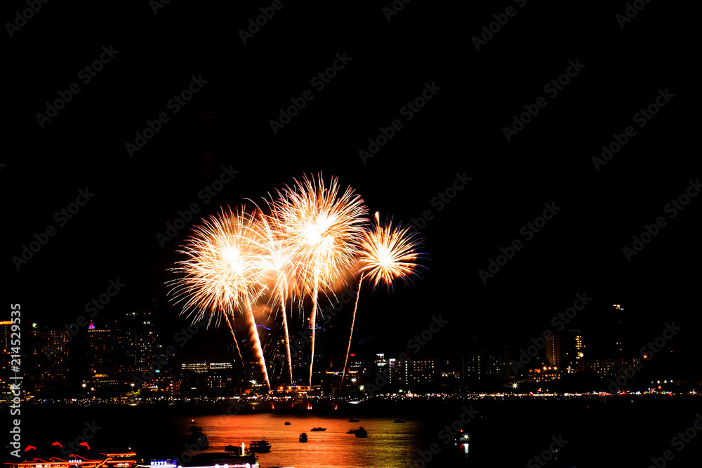 Many flashing fireworks with night cityscape background celebrate New Year.