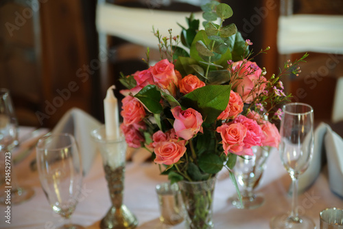 Wedding Reception Table Decorated with Silver and a Pink, White, and Green Centerpiece of Roses