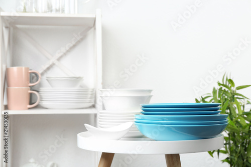 Different clean tableware on small table in kitchen