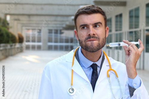 Doctor injecting himself in the hospital photo