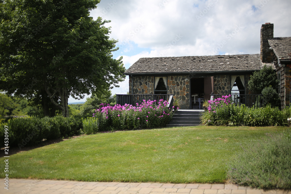 Stone Building Exterior with Purple Phlox Flowers Growing in a Garden in Front Stone Building Exterior with Purple Phlox Flowers Growing in a Garden in Front