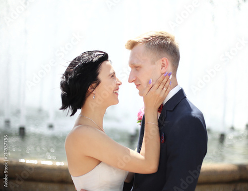closeup portrait of bride and groom standing next to the fountain © yurolaitsalbert