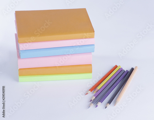 colored pencils and stack of books on white background. photo wi