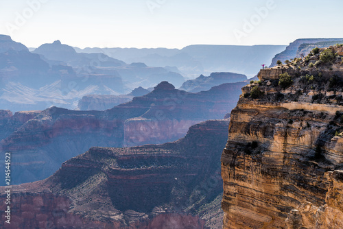 Girl in Jeans Suite is Standing on the Edge of Grand Canyon and Meeting Sunrise