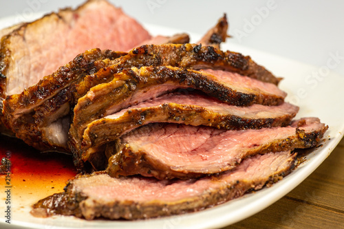 Grilled tri tip steak sliced on a white plate on the kitchen table