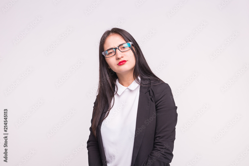 Serious brunette girl in studio wearing glasses on white background