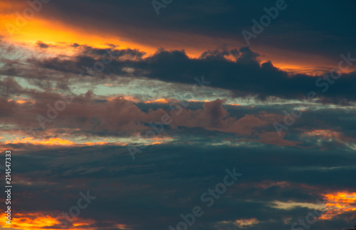 Colorful gold and blue sky with clouds on fire at sunset