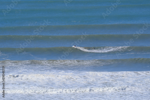 Jet ski towing surfer to peak of a large wave after a storm on the Gold Coast