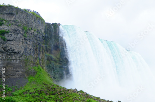 Tourists watching the green water cascade over Niagara Falls