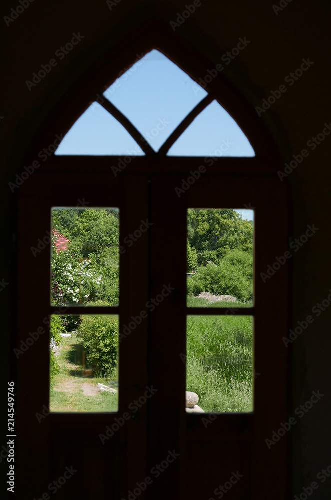 Arched window looking out to green landscape Arched window looking out to green landscape