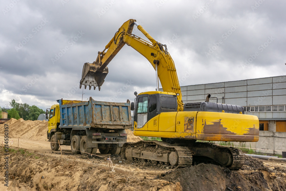 Excavator load the earth into a dump truck