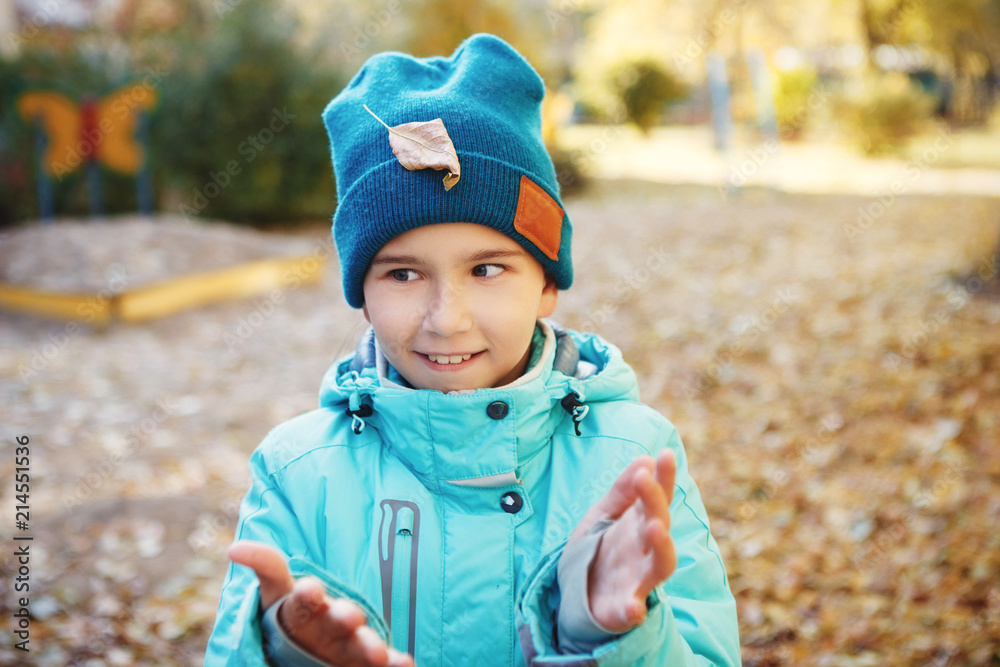 Cute teen girl in blue jacket and green hat, clapping hands, smiling looking left Cute teen girl in blue jacket and green hat, clapping hands, smiling looking left