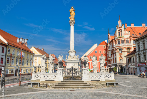 Maribor, Slovenia - May 22, 2018: Main square building and plague column in Maribor city, Slovenia, Europe. Historical religious sculpture and one of the best examples of baroque art in Slovenia photo