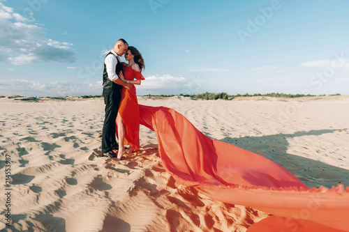 Photography A loving couple in the desert at sunset