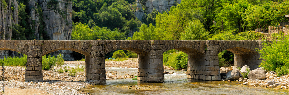 Large panoramic view of the old bridge over the Ardeche near Labeaume in France