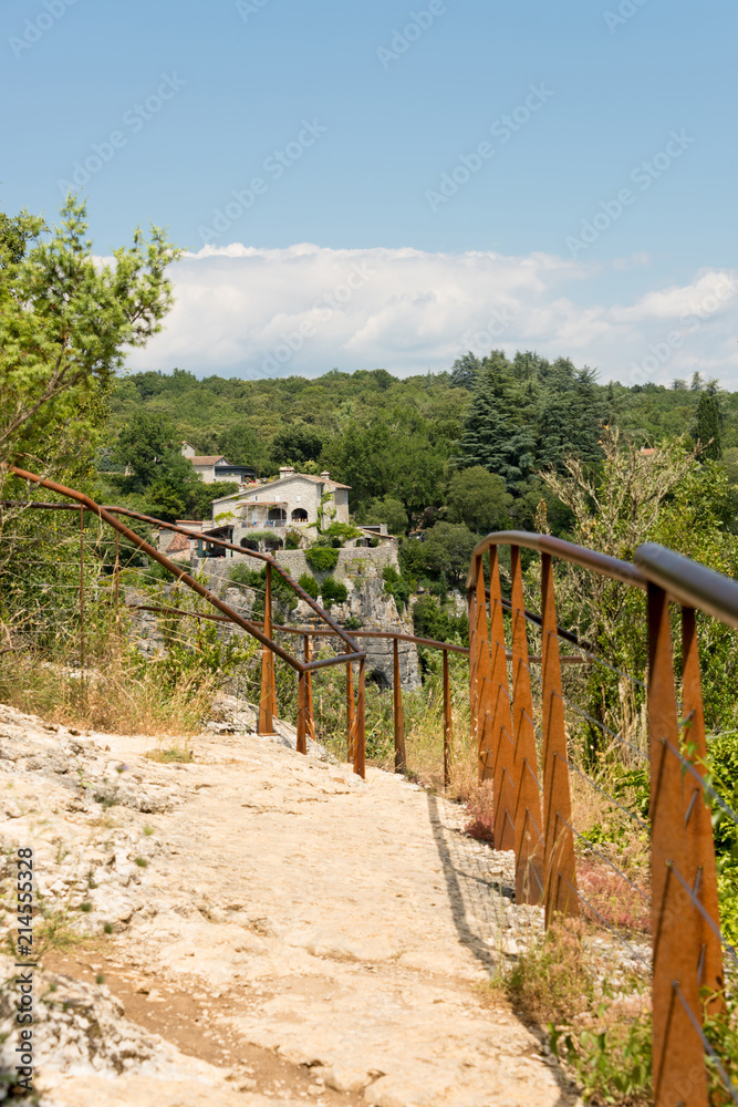 Rocky hiking trail secured with steel cables to the viewpoint above Labeaume at the river Ardeche in France