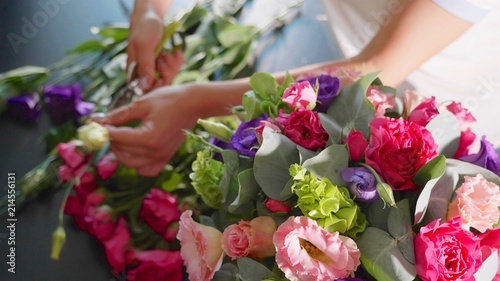 Florist girl makes a floral box in a flower salon, close-up