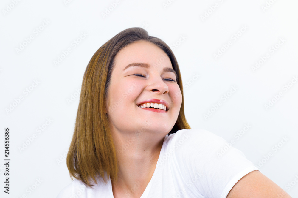 Pretty happy girl teenager in t-shirt laughs in white studio Pretty happy girl teenager in t-shirt laughs in white studio