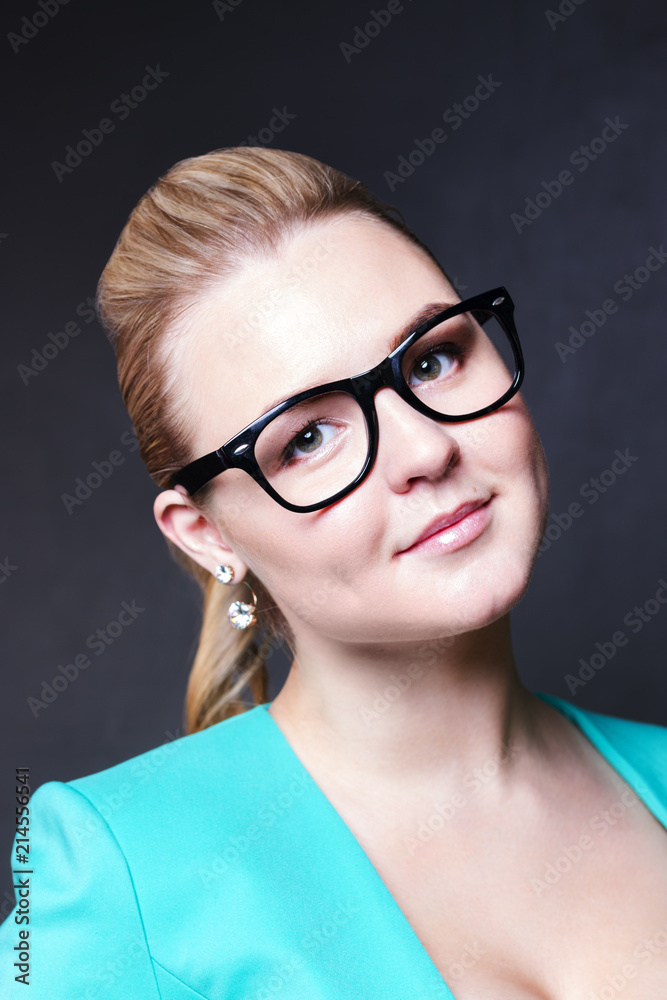 Pretty business blonde woman in glasses and jacket smiles in black studio Pretty business blonde woman in glasses and jacket smiles in black studio
