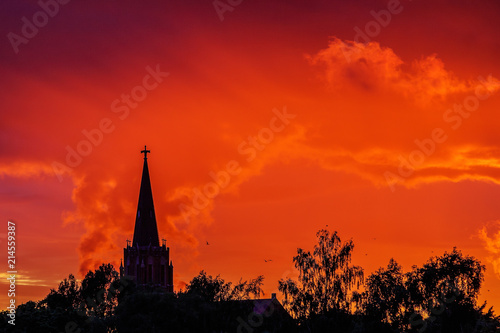 sun-dominated church towers with colorful skies © Normunds