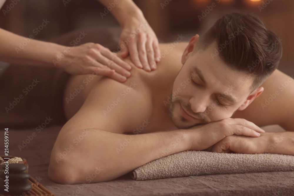 Young man receiving massage at spa salon