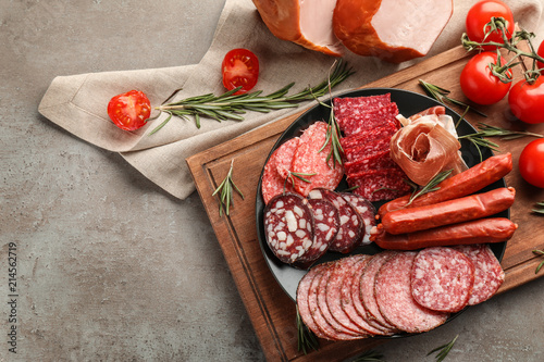 Obraz na płótnie Plate with assortment of delicious deli meats on grey background