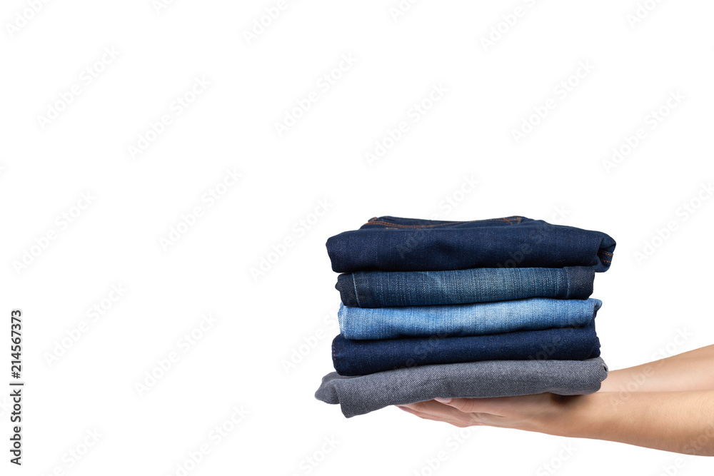 Foldet jeans in pile with hand, isolated on white background. copy space template Foldet jeans in pile with hand, isolated on white background. copy space template