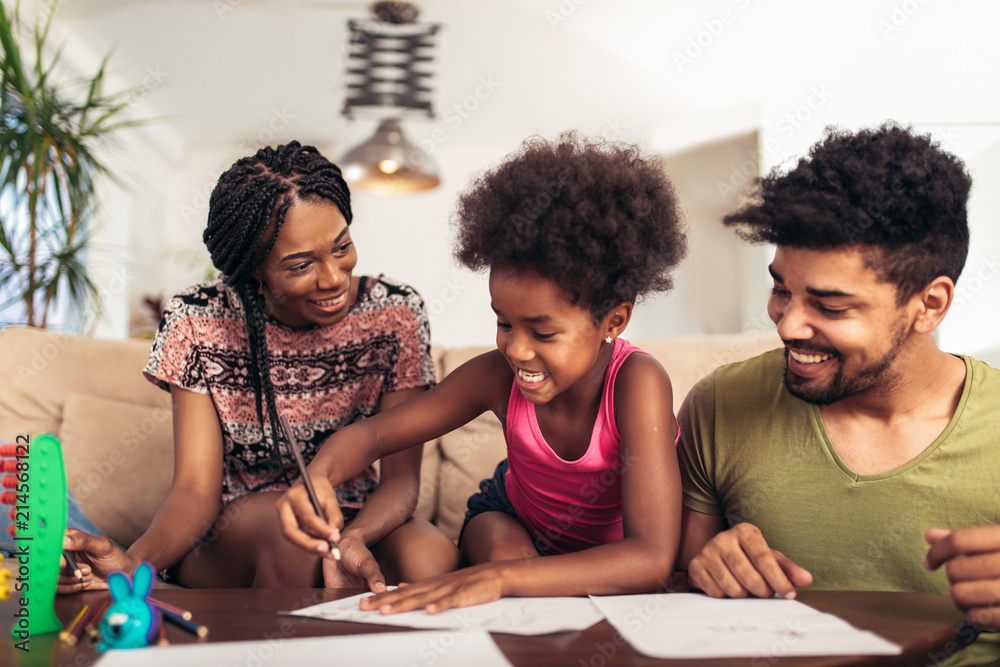 Mom and dad drawing with their daughter. African american family spending time together at home. Mom and dad drawing with their daughter. African american family spending time together at home.