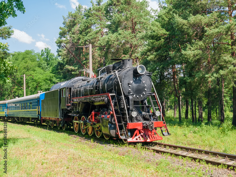Passenger train with steam locomotive in motion