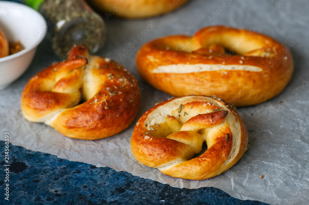 Traditional salted pretzels with oregano over blue stone background. Oktoberfest or beer snack concept. Traditional salted pretzels with oregano over blue stone background. Oktoberfest or beer snack concept.