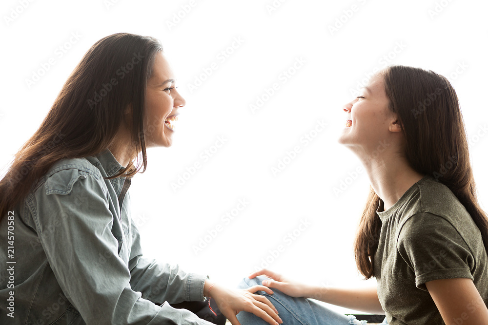Two sisters playing with each other and having a great time together over white background Two sisters playing with each other and having a great time together over white background