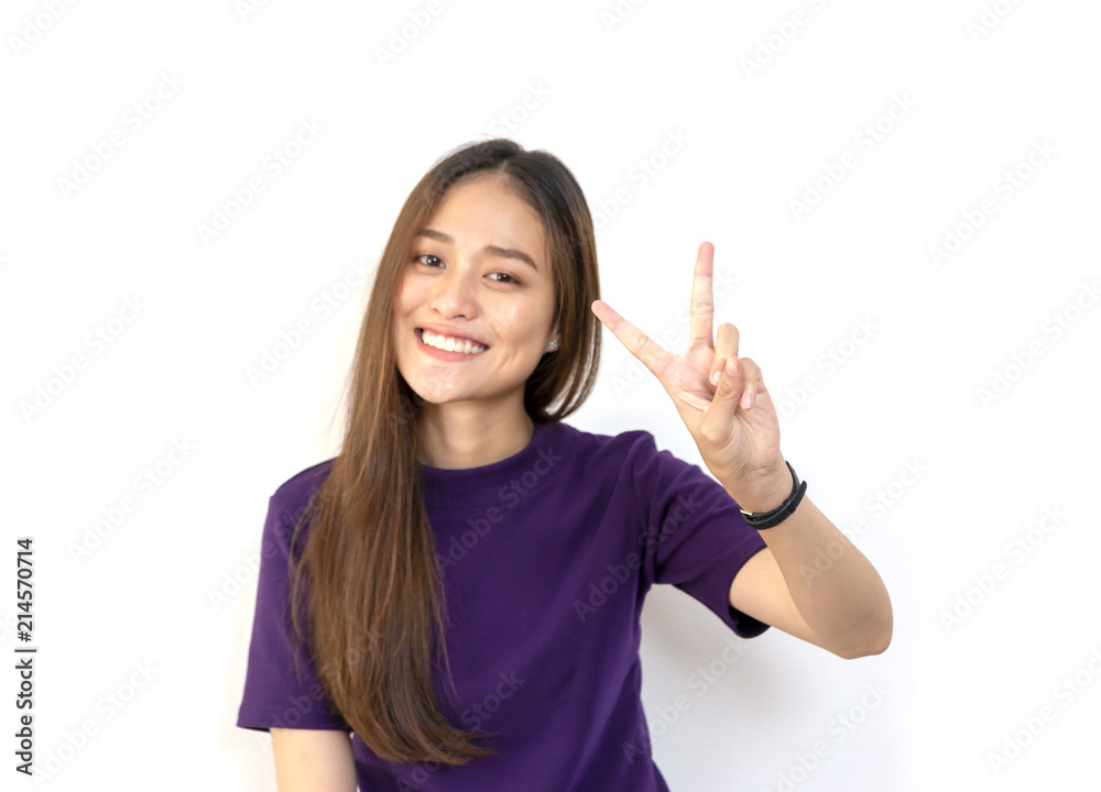 Portrait of a young smiling Asian woman showing peace gesture with white background Portrait of a young smiling Asian woman showing peace gesture with white background