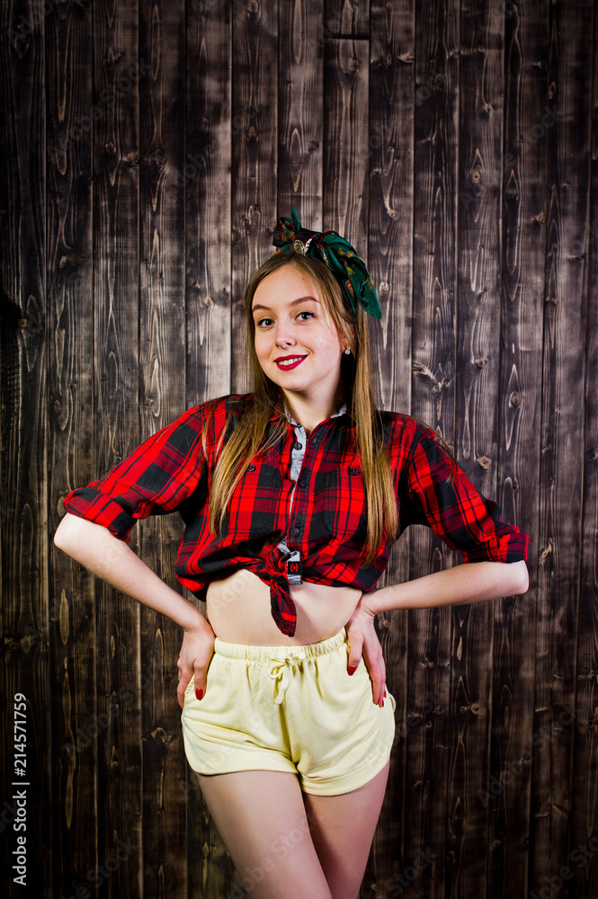 Young funny housewife in checkered shirt and yellow shorts pin up style on  wooden background. Stock-Foto | Adobe Stock