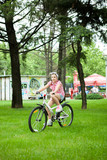 Girl feeling good while riding her bicycle in the park 