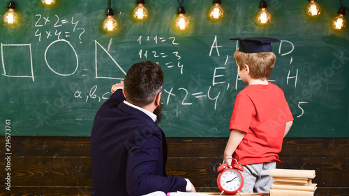 Bilde på lerret Teacher and schoolboy turned back in front of the green board