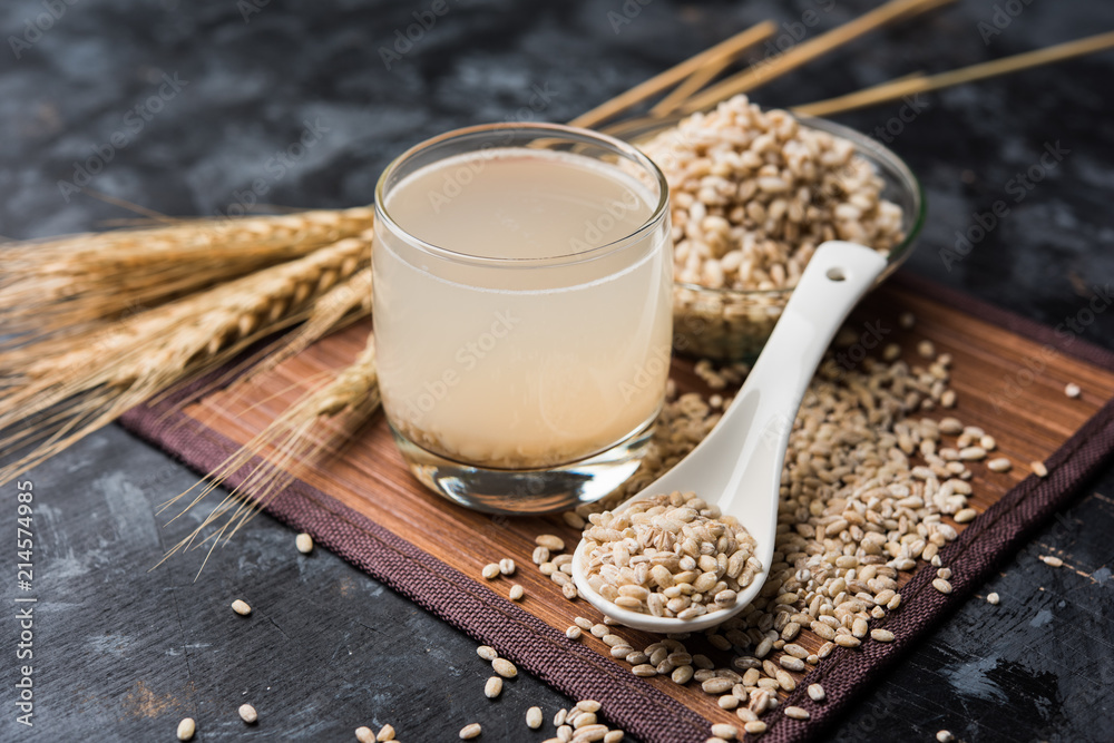 Barley water in glass with raw and cooked pearl barley wheat/seeds. selective focus Barley water in glass with raw and cooked pearl barley wheat/seeds. selective focus