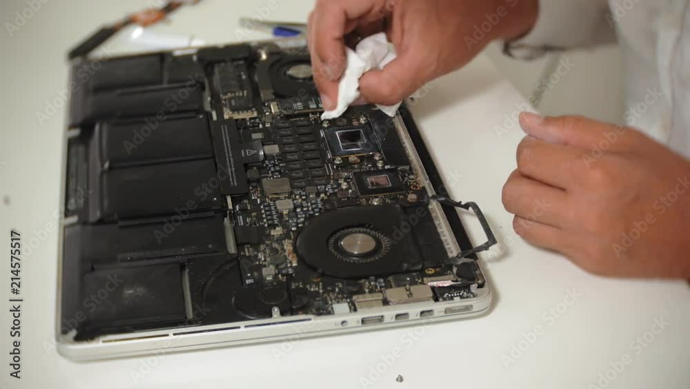 A man is repairing a laptop. The concept of computer repair. Close up of man repair laptop motherboard with a screwdriver. Maintenance of the hardware of the motherboard. Disc holder, computer repair A man is repairing a laptop. The concept of computer repair. Close up of man repair laptop motherboard with a screwdriver. Maintenance of the hardware of the motherboard. Disc holder, computer repair