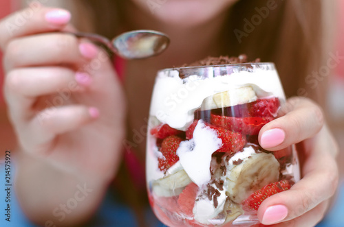 Strawberry dessert with chocolate chips, banana and sour cream in the glass.