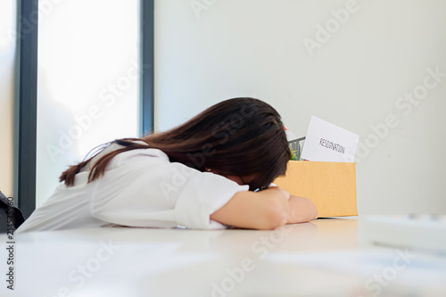  Business woman packing her belongings in cardboard box on desk leaving his office with his personal effects.