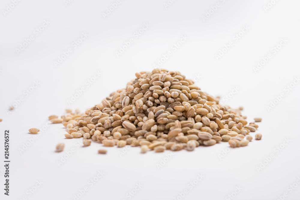 Raw and cooked Barley pearl seeds in a bowl or over white plate. selective focus Raw and cooked Barley pearl seeds in a bowl or over white plate. selective focus