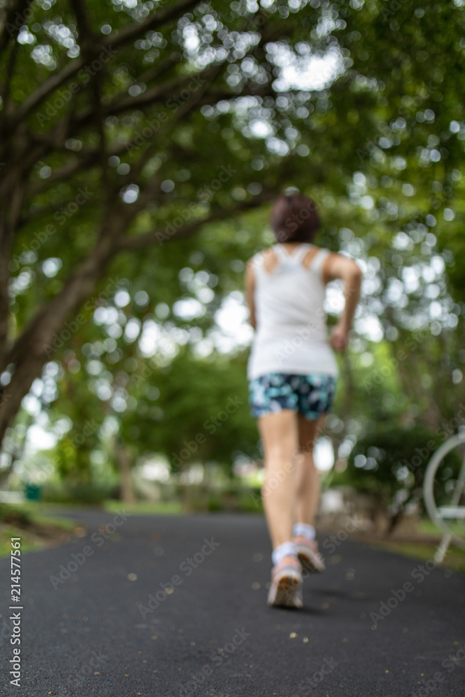 Asian woman jogging in the park with blurring style, shooting from behind