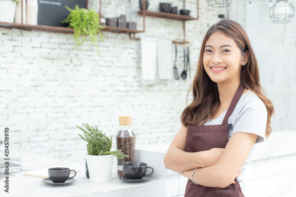 Asian Women Barista smiling and looking to camera in coffee shop counter. Barista female working at cafe. Working woman small business owner or sme concept.