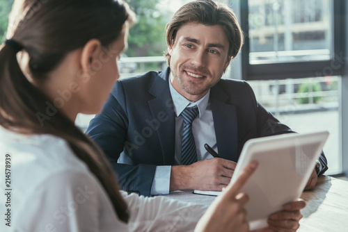 businessman and businesswoman working with tablet together at modern office