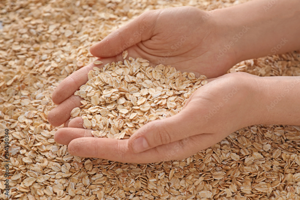 Female hands with oatmeal flakes, closeup