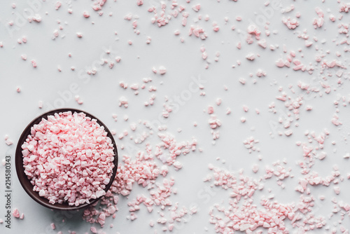 top view of pink sea salt in bowl on white background