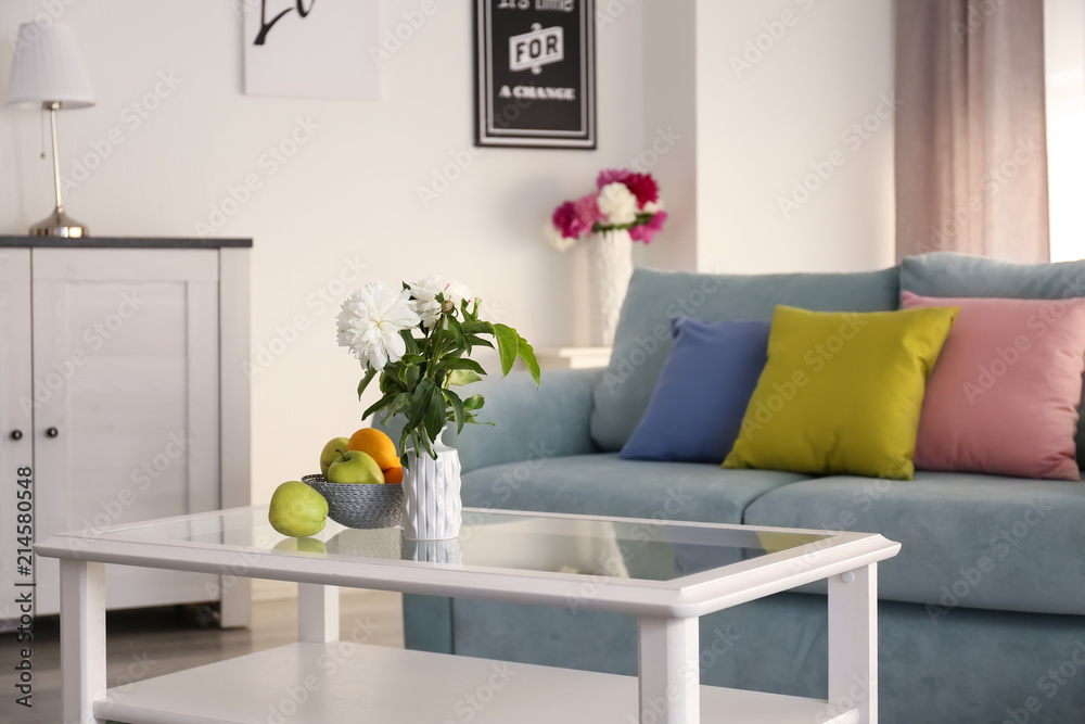 Naklejka premium Table with beautiful flowers in elegant interior of living room