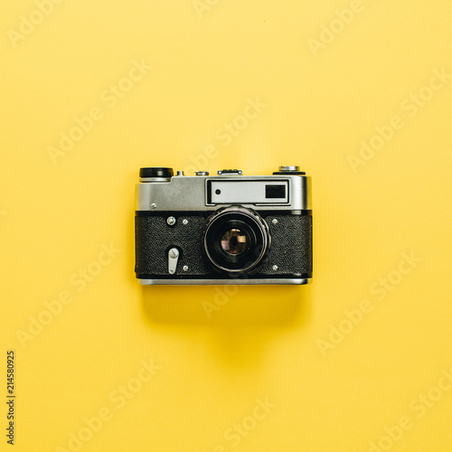 Vintage retro camera isolated on yellow background. Flat lay, top view.